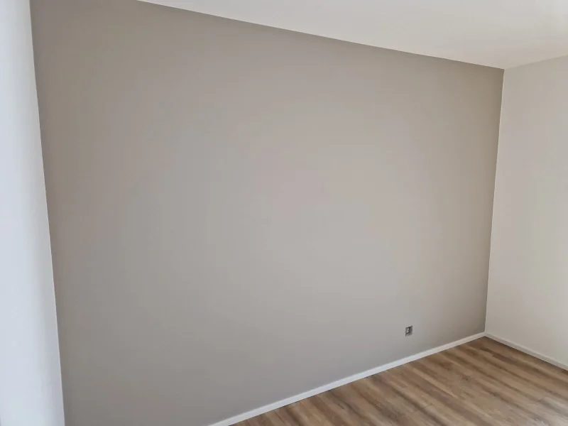 Pièce aux murs blancs avec un mur d’accent peint en taupe